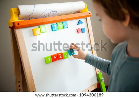 Cute little boy preschooler teaches math.