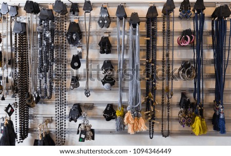 

picture of colored jewelry hanging on the stand in the store