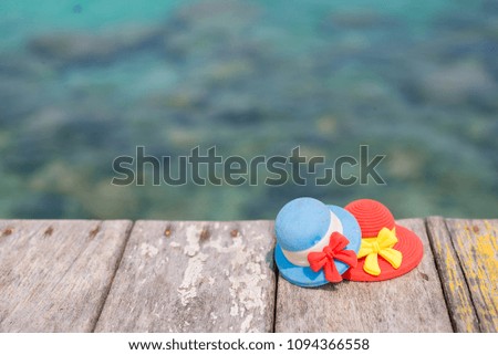 Miniature hats on beach chair with sea background.Vacation concept.