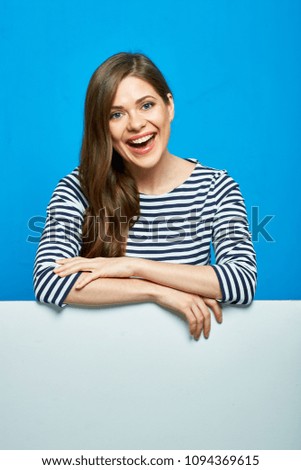 Smiling woman with white advertising copy space. Studio portrait on blue.