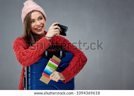 Happy girl tourist taking pictures with camera holding passport, ticket, credit card. Isolated portrait.