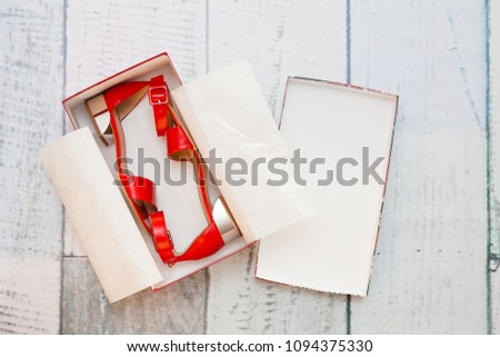 A pair of red sandals in a box Royalty-Free Stock Photo #1094375330
