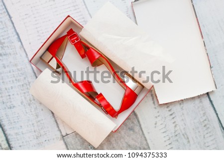 A pair of red sandals in a box Royalty-Free Stock Photo #1094375333