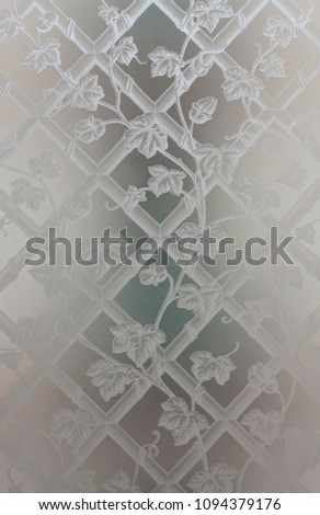 Decorative opaque glass with drawn flowers endraved. Domestic object vintage retro. Blurred background