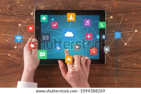 Hand touching multitask tablet with cloud wifi message social media call icons and symbols concept