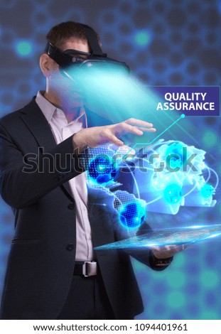 Business, Technology, Internet and network concept. Young businessman working in virtual reality glasses sees the inscription: Quality assurance