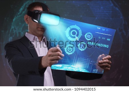 Business, Technology, Internet and network concept. Young businessman working in virtual reality glasses sees the inscription: Rebranding