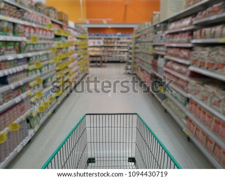 trolley in a supermarket, products on shelves are blurred background
