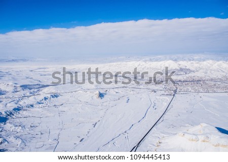 Snowscape and ballooning with vivid blud sky via bird-eye-view