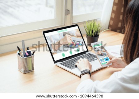 Businesswoman in office in casual shirt. Use computer for graphic designer and choose a color sample to match the publication.