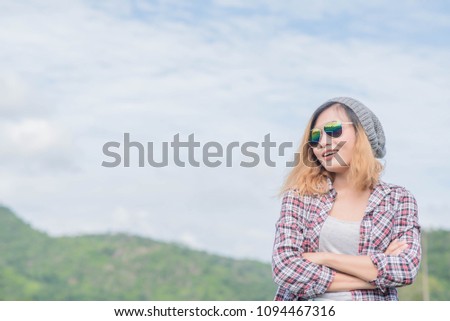 portrait of a young woman standing wearing glasses to take a picture in the park with a holiday.