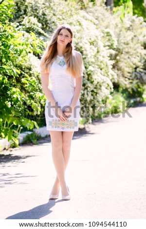 Portrait of a beautiful model in a white dress. Vertical photo. Beautiful smile.