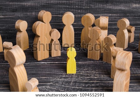 The child was lost in the crowd. A crowd of wooden figures of people surround a lost child. Lost, parents who have lost their parents are a small child. An orphan, a beggar, a lonely kid