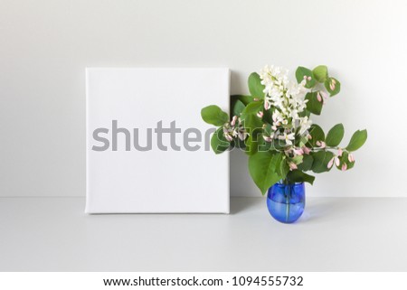 Mockup poster in neutral interior. White square canvas and bouquet of flowers.

