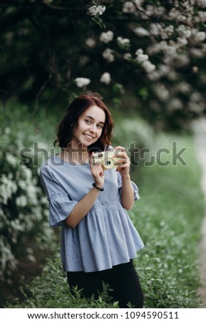 Photography, hobby, leisure, travel, sightseeing. Young smiling woman with retro camera at nature background