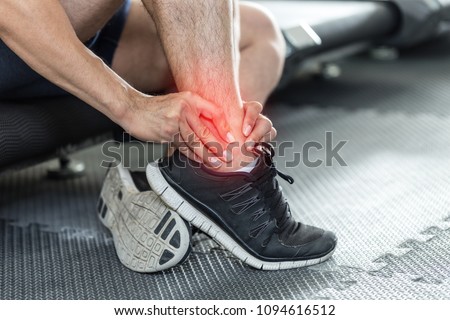 Asian man injury ankle pain after training running workout in gym feeling so pain,Healthcare Concept Royalty-Free Stock Photo #1094616512