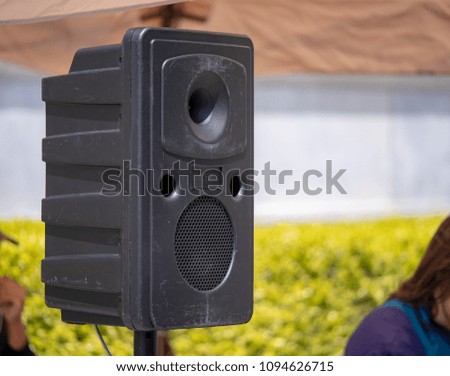 Standing speaking projecting music at a musical performance at an outdoor area