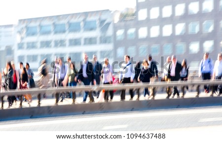 London, UK. Blurred image of office workers crossing the London bridge in early morning on the way to the City of London, the leading business and financial area in Europe. Rush hours