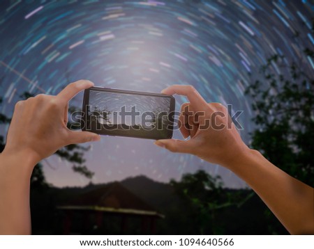 Hands holding phone take a photo star on sky in night scene.Selective focus.