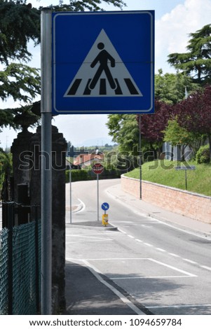Pedestrian crossing road sign, more signs visible in the distance