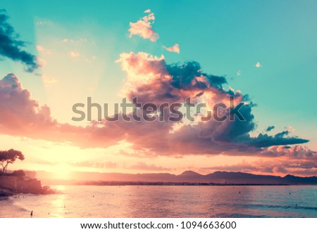 View of the sunset on the sea in a vintage style. The sun shines through the clouds.
