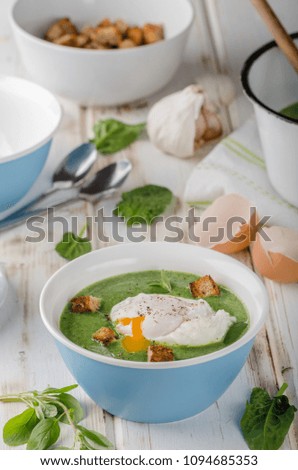Spinach soup with poached egg, fresh croutons and herbs in, photo stock advertisment