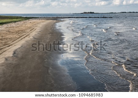 At Grand Isle, Louisiana, the channel entrance to Caminada and Barataria Bays with the ruins of Fort Livingston on Grande Terre Island in the background. Royalty-Free Stock Photo #1094685983