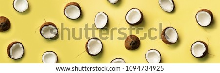 Pattern with ripe coconuts on yellow background. Top View. Copy Space. Pop art design, creative summer concept. Banner. Half of coconut in minimal flat lay style