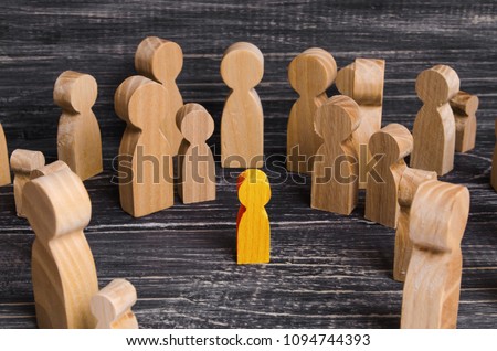 The child was lost in the crowd. A crowd of wooden figures of people surround a lost child. Lost, parents who have lost their parents are a small child. An orphan, a beggar, a lonely kid