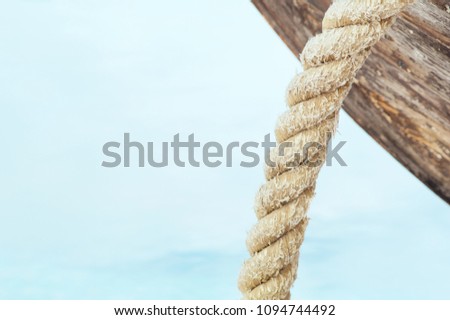 Close-up of an old ship with a rope on the water. Place for your inscription is in the left corner