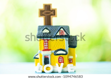 Home Church model and cross with fish symbol of christian on green nature background.Body of Christ and Church concept.