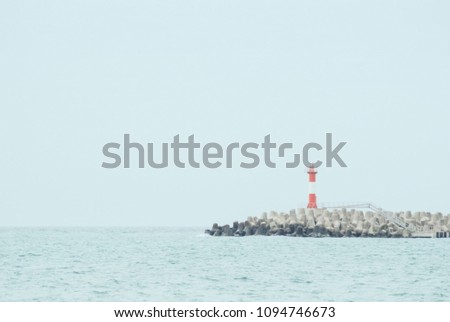 Lighthouse on breakwaters. Summer day at the sea