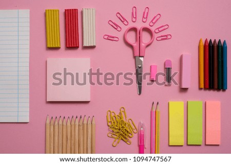 Stationary concept, Flat Lay top view Photo of Scissorsschool supplies, notepad and pens, color pencils, on a pink background. pink background with copy space.