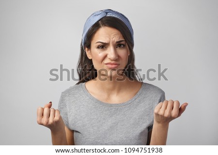 Irritated angry beautiful young housewife can't hide her negative emotions, being annoyed with her irresponsible husband, frowning and clenching fists in fury. Beautiful girl feeling mad and irritated Royalty-Free Stock Photo #1094751938