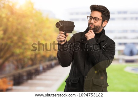 young man holding a video camara
