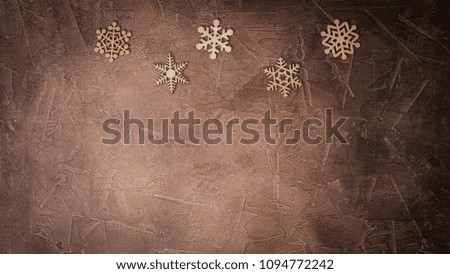 Handmade wooden snowflakes on the brown background, Christmas congratulation concept, flatlay