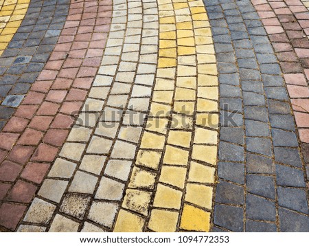 Close-up paving slabs by mosaic. Road paving, construction. Tessellated sidewalk tile. Colored concrete paving slab.