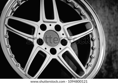 Close-up of aluminium rim of luxury car wheel. Detail background