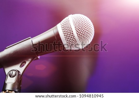 close up photo of professional microphone standing at a boom. dj tool illuminated by purple light. concept of party clubbing lifestyle