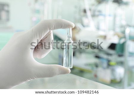 colorless vials of medicine in the doctor's hand against the backdrop of a hospital ward.