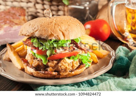 Chickenburger with bacon, tomato, cheese and lettuce served with french fries and beer