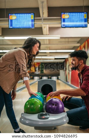 Shot of a young couple choosing bowling balls