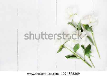 Styled stock photo. Feminine wedding table composition with white peonies flowers on old white wooden background. Empty space. Top view. Picture for blog.