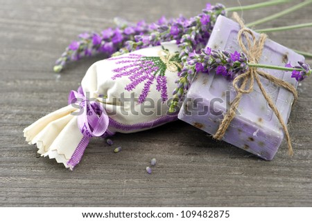 closeup of lavender soap and scented sachets with fresh flowers over wooden background