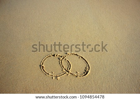 On the sand there are rings. Concept: a wedding, a shaky relationship, a temporary love.