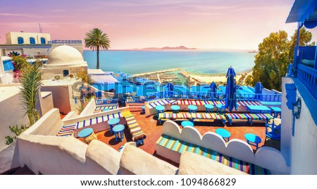 Panoramic view of seaside and cafe terrace in Sidi Bou Said at sunset. Tunisia, North Africa   Royalty-Free Stock Photo #1094866829