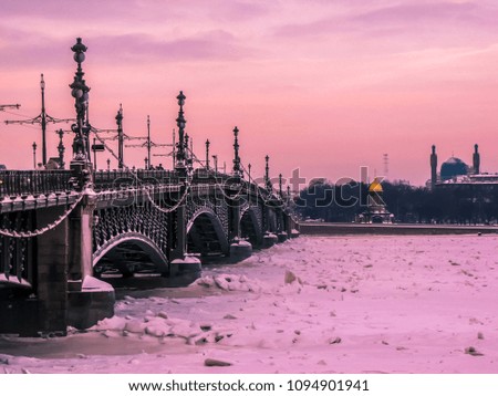 The Annunciation Bridge (Russian: Blagoveschensky Most) in winter at sunset. In the background, the St. Petersburg Mosque. In St. Petersburg, Russia 