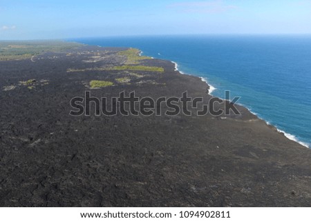 Helicopter aerial view of lava entering the ocean and steam, Big Island, Hawaii.