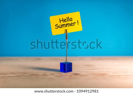 Hello Summer - text on a little yellow tag on blue bright background. First summer day. Happy Childrens Day