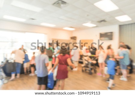 Blurred motion people attending vendor table stands at public event in Irving, Texas, USA. Abstract background booth registration, information to promotional gift exchange